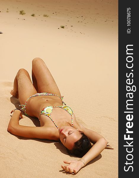 Woman lie on the sand beach under the sun
