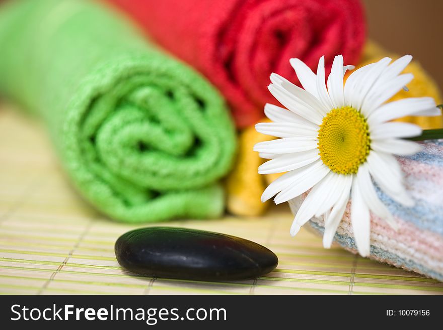 An image of a chamomile, towels, sponge, stone. An image of a chamomile, towels, sponge, stone