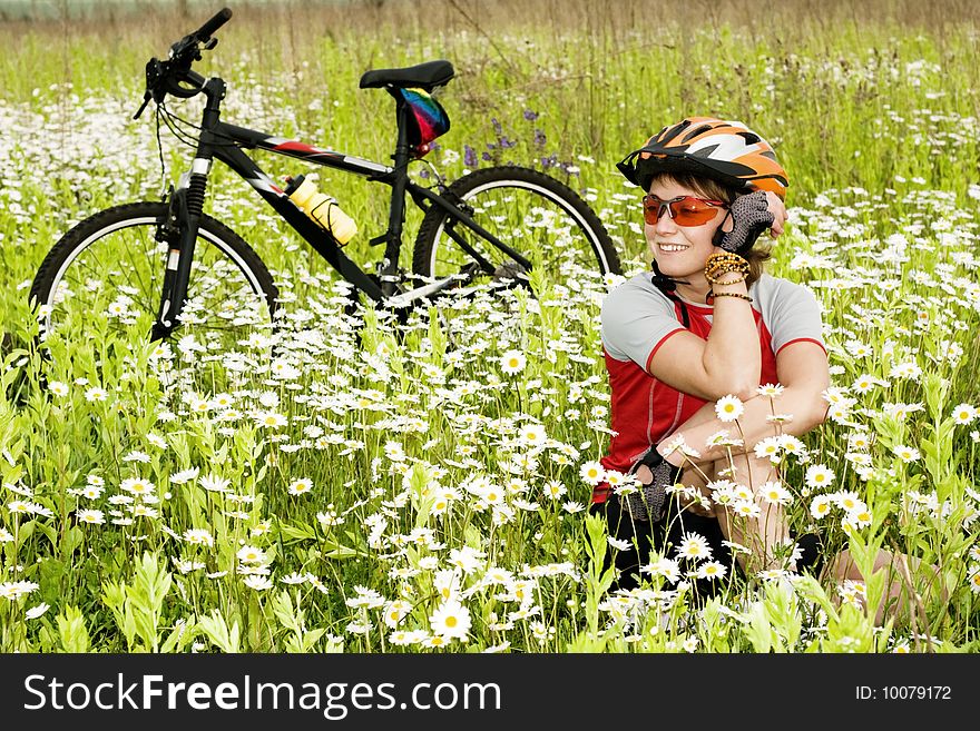 An image of a girl and bicycle in a field. An image of a girl and bicycle in a field