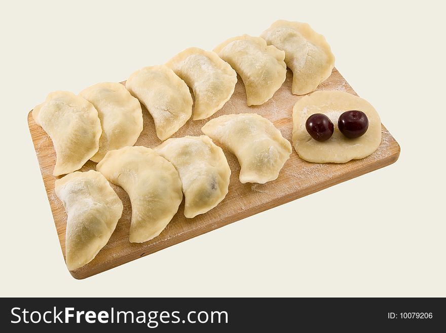 Pelmeni with a cherry on a board on a white background. Pelmeni with a cherry on a board on a white background