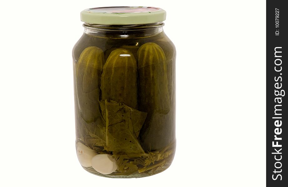 In a glass jar marinaded cucumbers on a white background