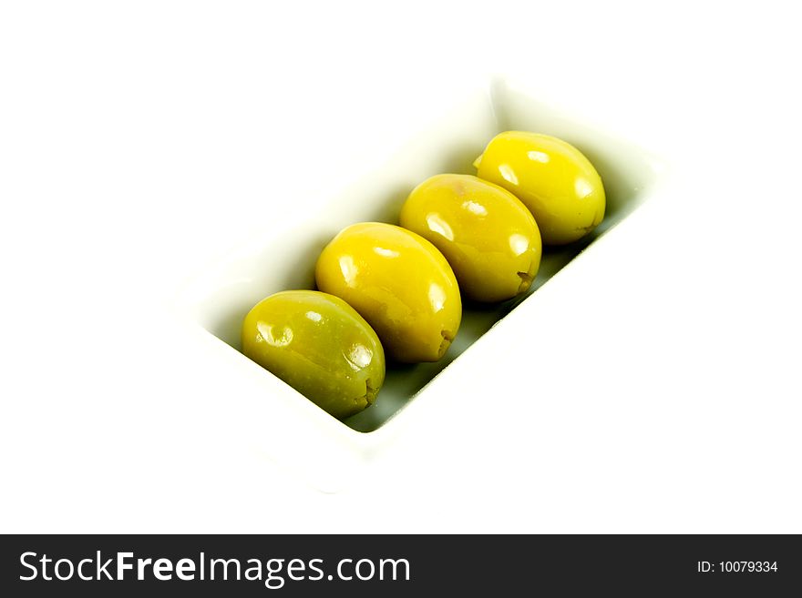 Four green olives in a small dish on a white background. Four green olives in a small dish on a white background