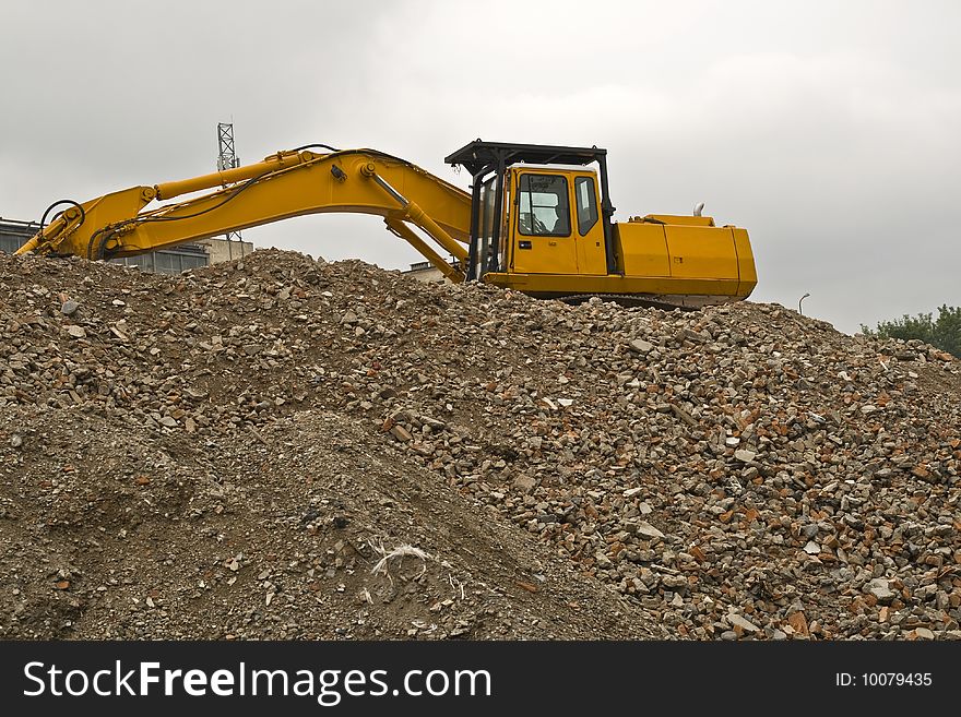 Backhoe is working during demolition of building