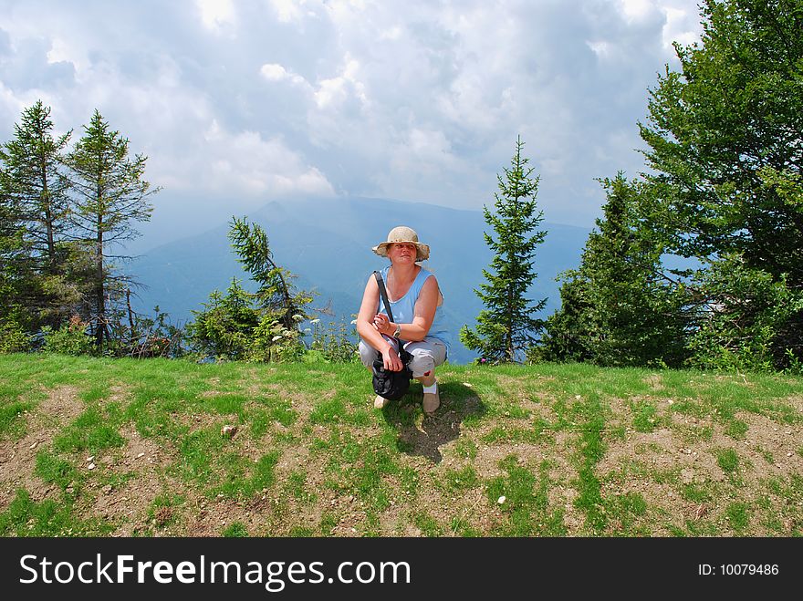 The Alpes. Italy. Solar summer day. A smoke. The having a rest woman against mountain tops. The Alpes. Italy. Solar summer day. A smoke. The having a rest woman against mountain tops.