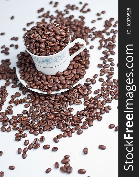 Cup of coffee beans on white background