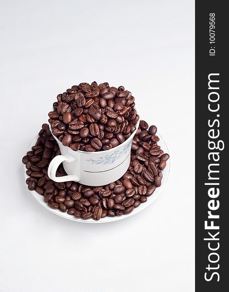 Cup of coffee beans on white background