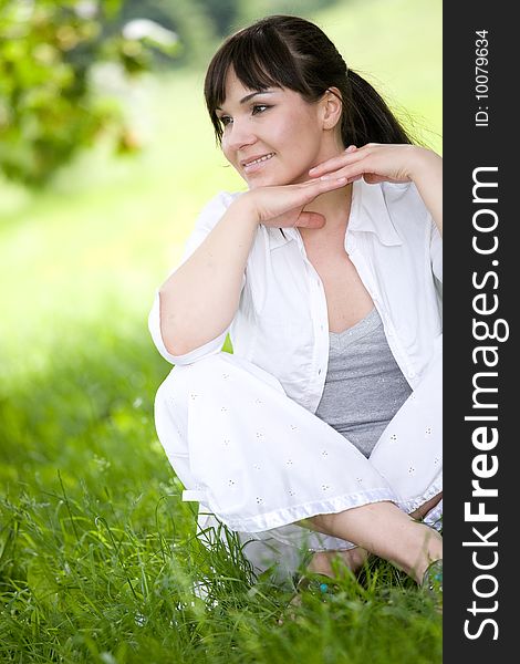 Happy young woman relaxing on grass. Happy young woman relaxing on grass