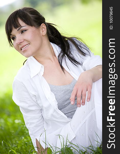 Happy young woman relaxing on grass. Happy young woman relaxing on grass