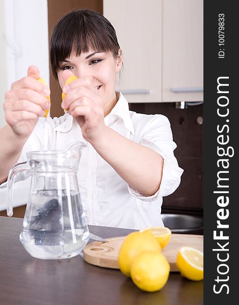 Young brunette woman making lemon juice