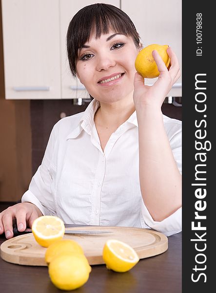 Young brunette woman making lemon juice