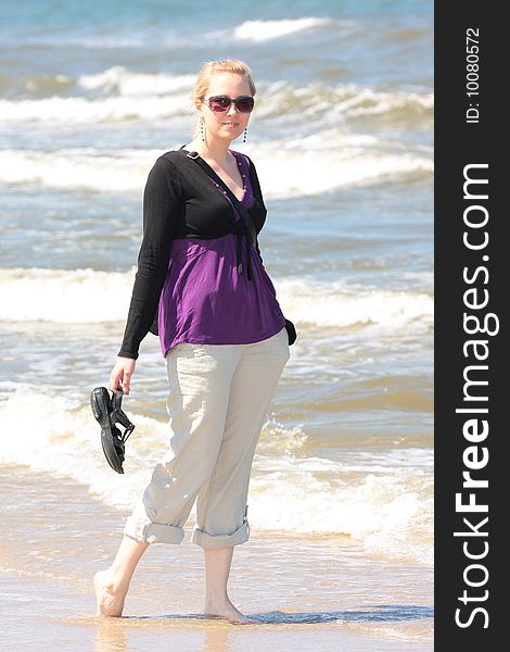 Blond smiling girl walking on the beach. Blond smiling girl walking on the beach