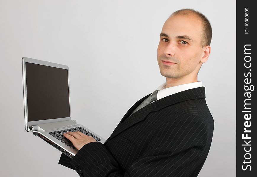 Business man with laptop. Gray background