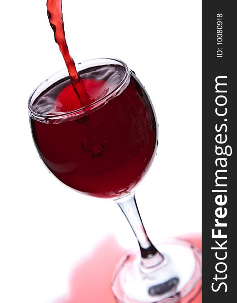 Red wine pouring into glass isolated