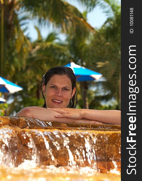 Young woman in a beautiful pool with palms in the background. Young woman in a beautiful pool with palms in the background.