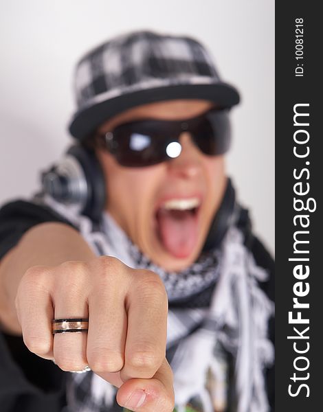 A young DJ is pointing at the camera and screaming. The focus is on his fist! Isolated over white. A young DJ is pointing at the camera and screaming. The focus is on his fist! Isolated over white.