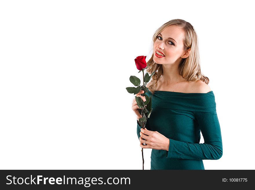 A girl holds up a rose to her nose. A girl holds up a rose to her nose