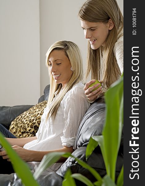 Two female models reading and relaxing in sitting room setting. Two female models reading and relaxing in sitting room setting