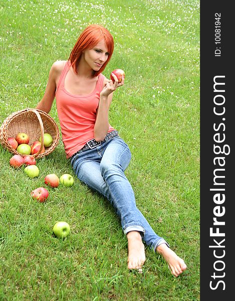 Beautiful girl with a basket of apples on a meadow. Beautiful girl with a basket of apples on a meadow