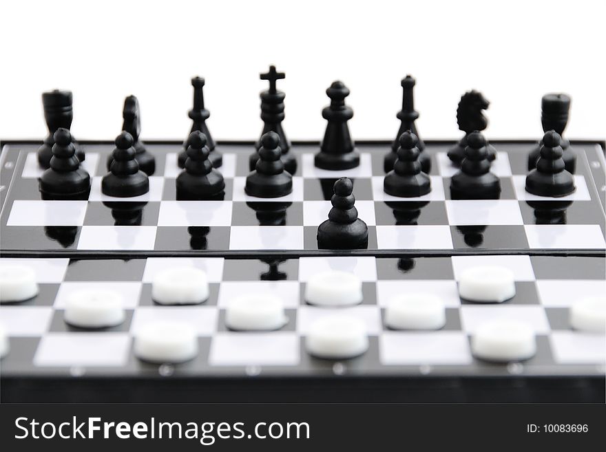 Black chess against whit checkers on the board. Black chess against whit checkers on the board