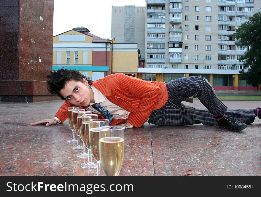 Young man with champagne rests on the pedestal