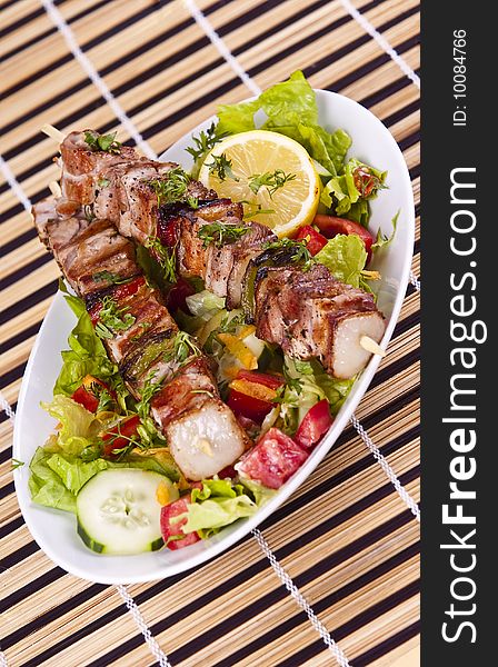 Grilled chicken kebab served with a fresh salad