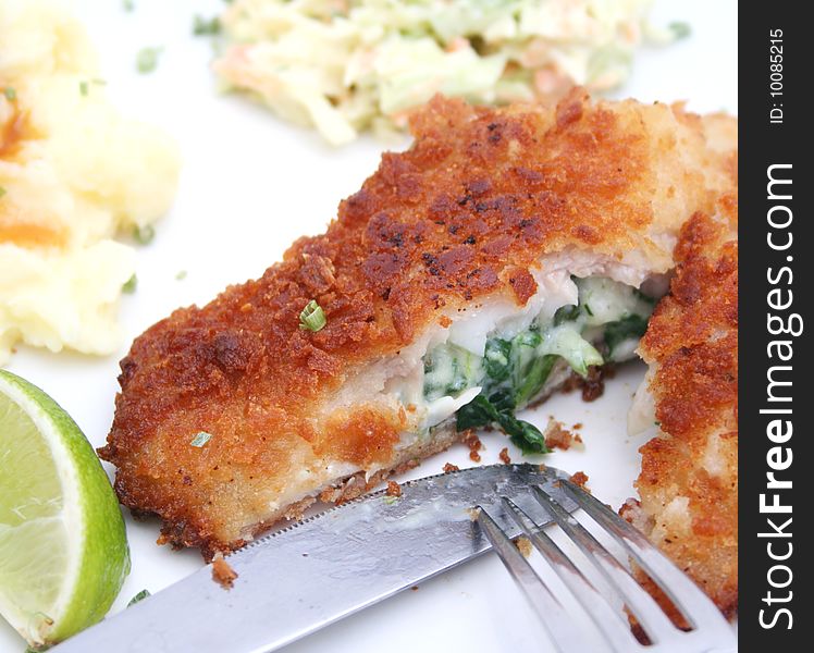 A meal of fish filled with spinach, potatoes and cabbage-salad. A meal of fish filled with spinach, potatoes and cabbage-salad