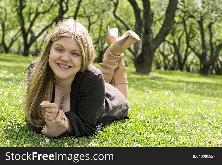 Smiling woman with blond hair relaxing in the park