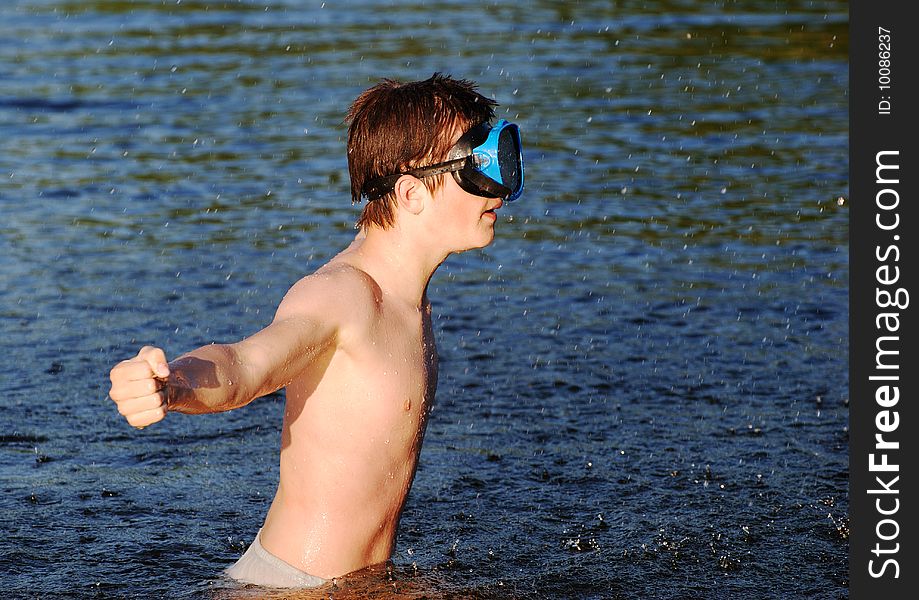 The boy with a mask playing water games in a lake. The boy with a mask playing water games in a lake.