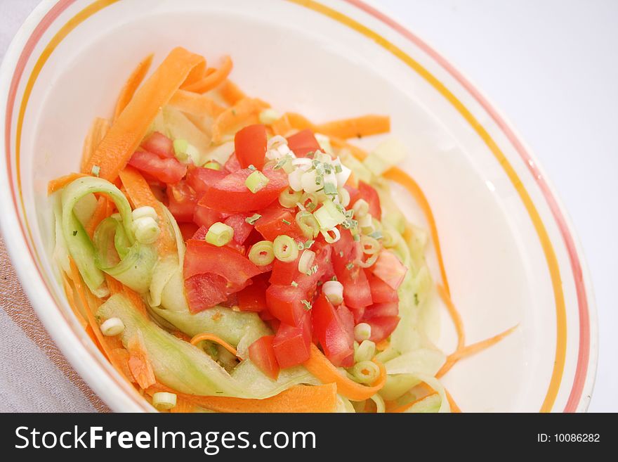 A fresh salad of cucumbers, carrots and tomatoes