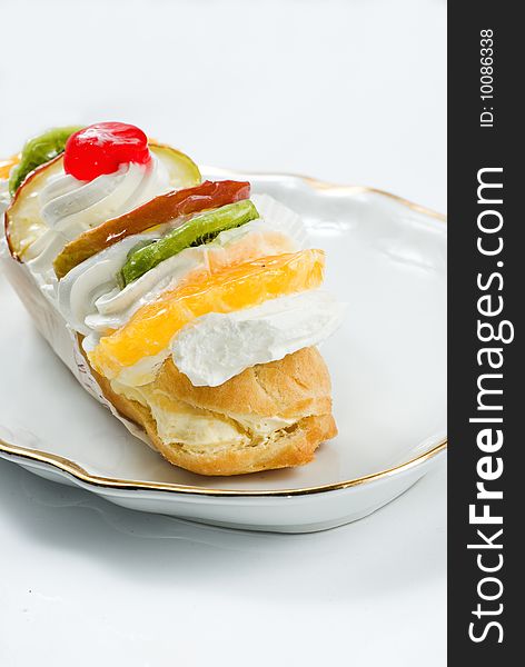 Fruity pastry with fruits and whipped cream with focus on orange. Fruity pastry with fruits and whipped cream with focus on orange