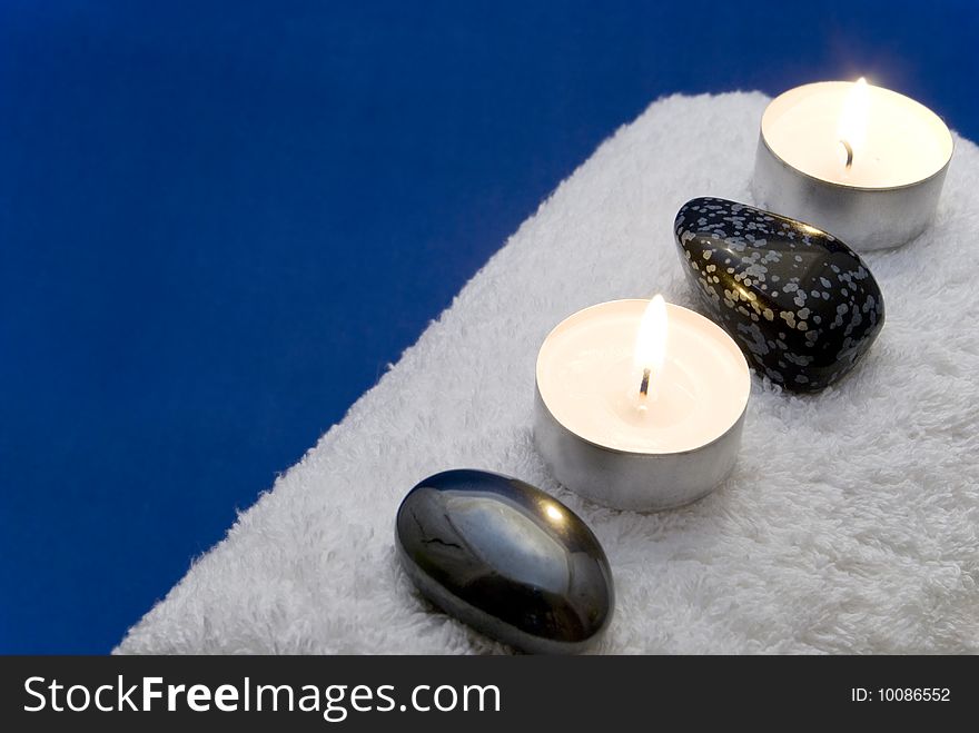 Candles and massage stones on a towel. Candles and massage stones on a towel
