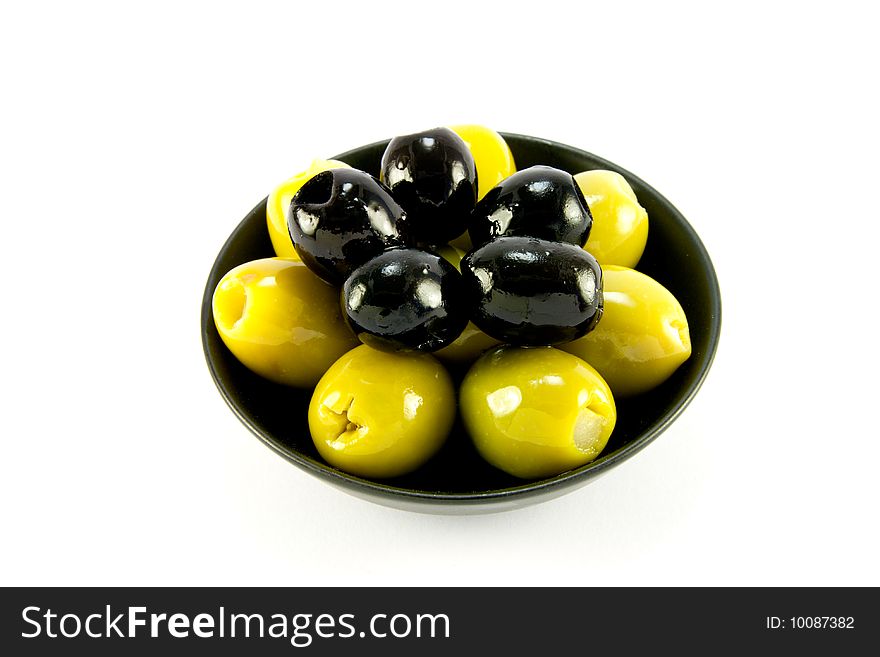 Green and black olives in a small black bowl on a white background. Green and black olives in a small black bowl on a white background