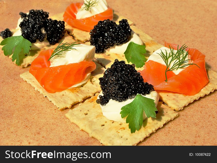 Canape - crackers with cream cheese, caviar and salmon