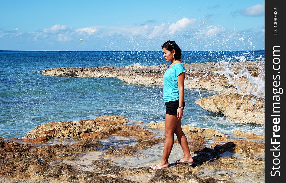 The girl on Seven Mile Beach with water splashes in a background (Grand Cayman). The girl on Seven Mile Beach with water splashes in a background (Grand Cayman).