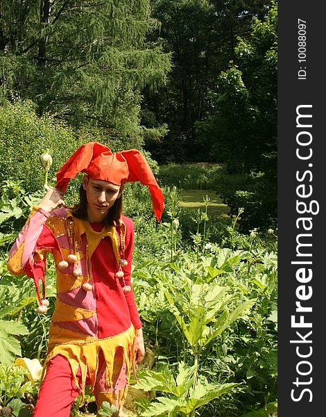 Man dressed in a clown`costume walking in a park