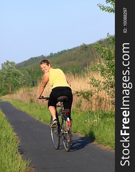 Happy young girl with a bike in front of the camera