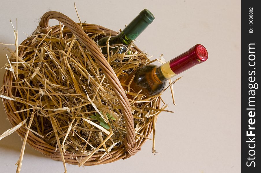 Bottles of wine in the basket with straw.