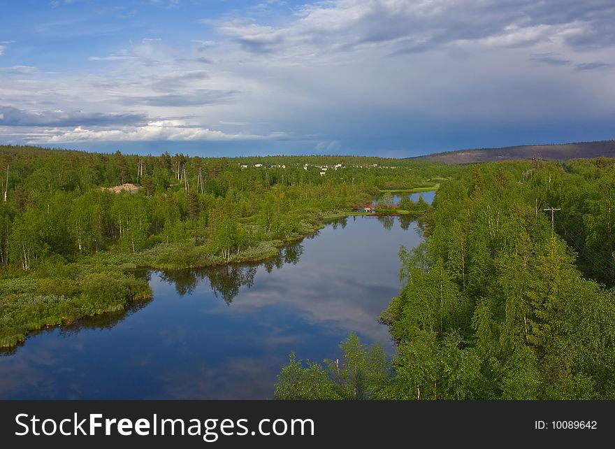 Clouds are reflected in silent northern small river among green hills. Clouds are reflected in silent northern small river among green hills