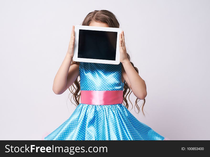 Young Girl with Tablet. Portrait child in blue Dress. Technologies. Young Girl with Tablet. Portrait child in blue Dress. Technologies.