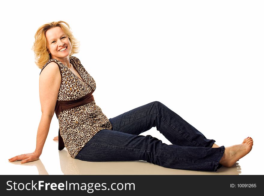Adult woman poses sitting on floor wearing jeans and no shoes. Adult woman poses sitting on floor wearing jeans and no shoes.