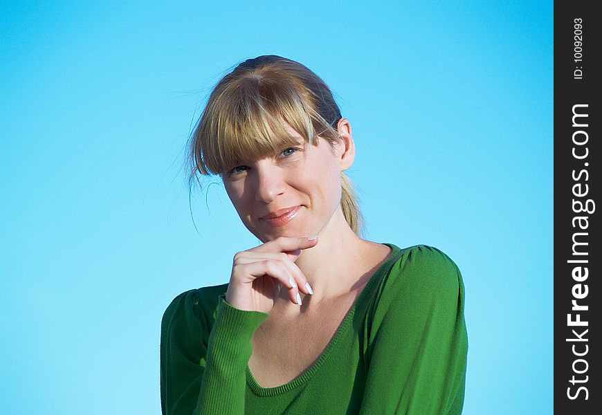 Portrait of the young woman posing on a background of the dark blue sky. Portrait of the young woman posing on a background of the dark blue sky