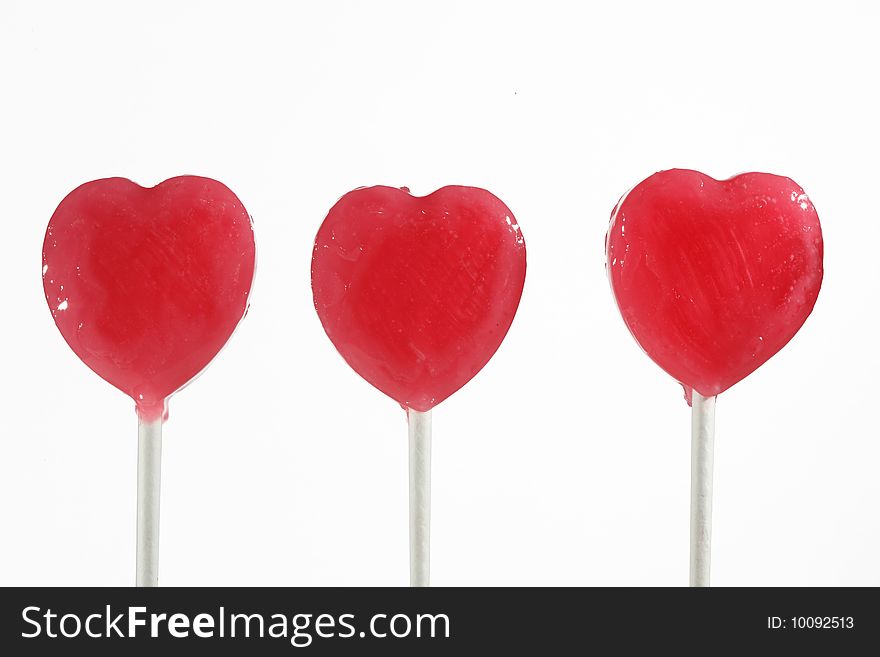 Three red heart lollipops isolated