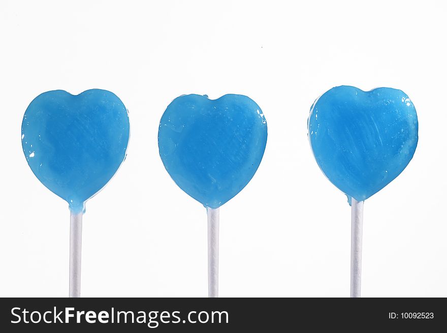 Three blue heart lollipops isolated