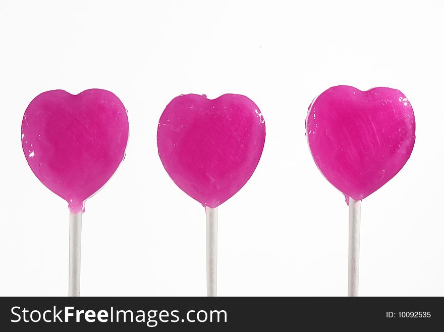 Three pink heart lollipops isolated