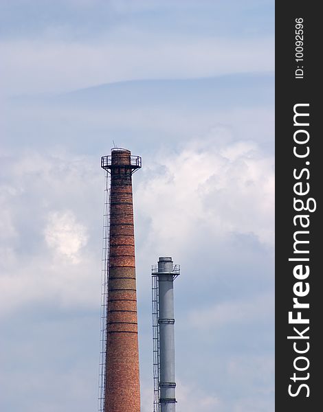 Big industrial chimneys polluting our environment, with blue sky in background
