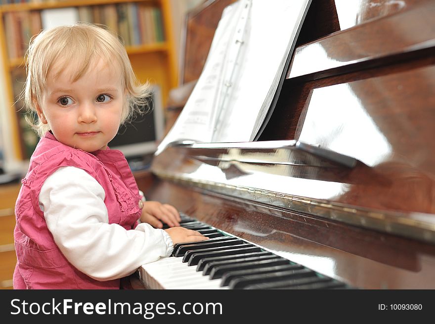 Beautiful little girl plays  piano