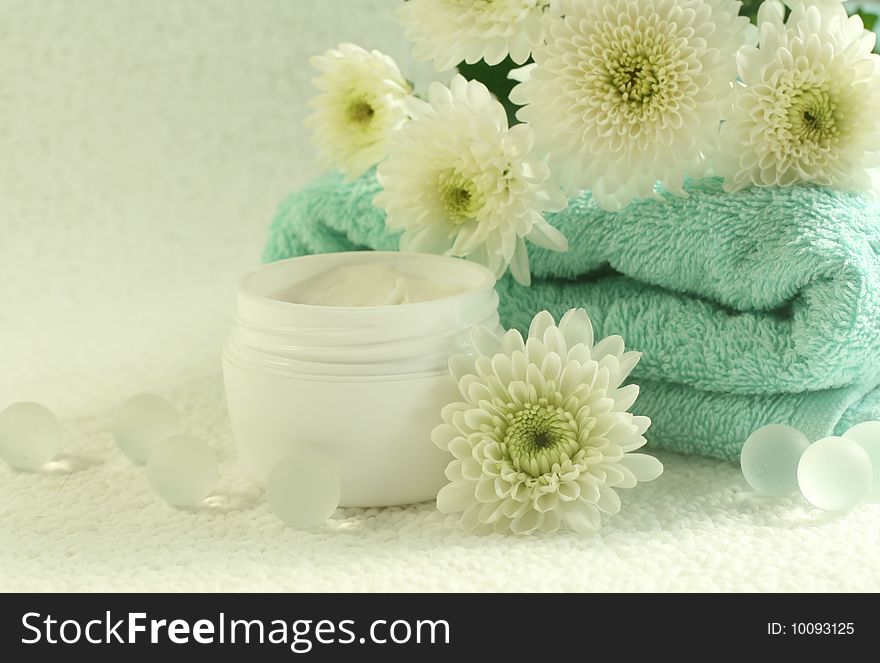 Bowl of cream, towel and flowers. Spa composition.