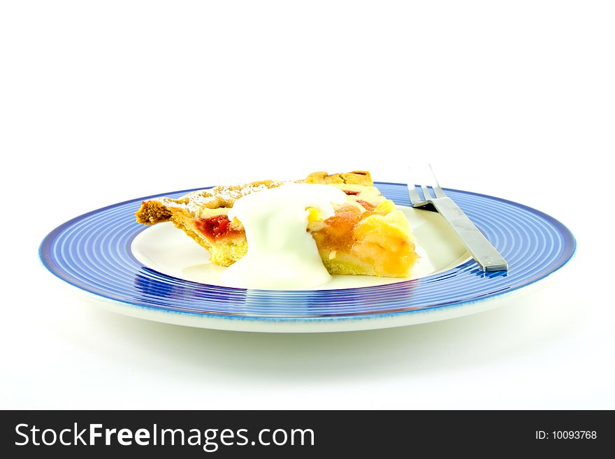 Slice of apple and strawberry pie with cream and a fork on a blue plate with a white background. Slice of apple and strawberry pie with cream and a fork on a blue plate with a white background