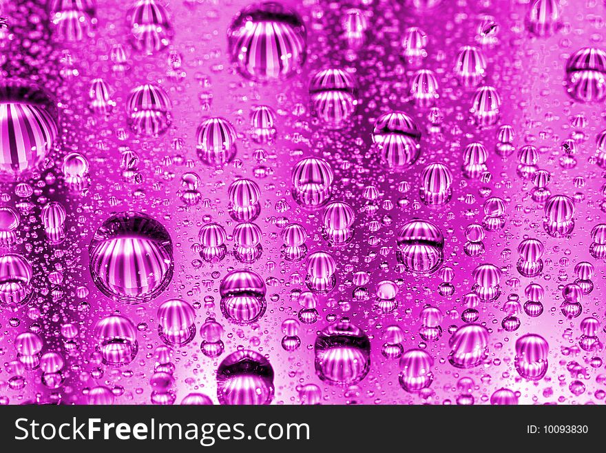 Pink water drops against mirror