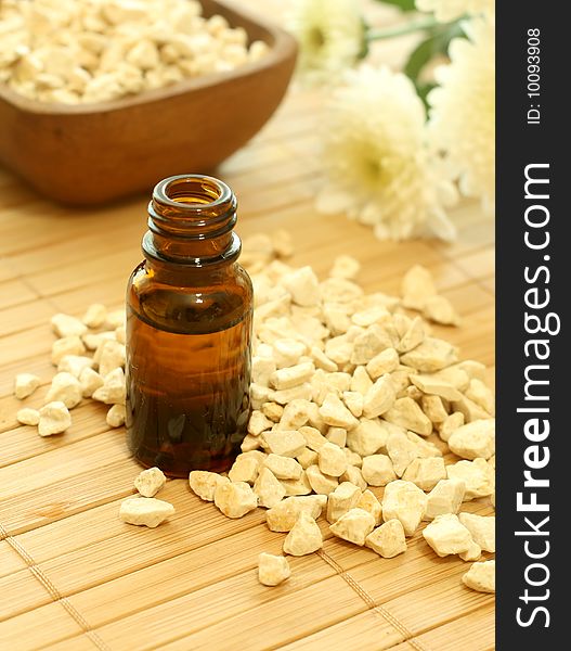 Bottle of essence oil with flowers and stones. Spa concept.